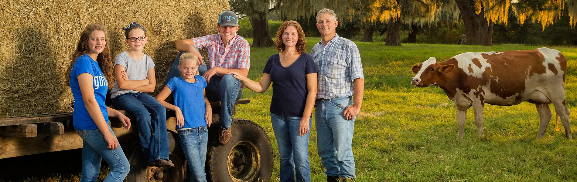 Heijkoop Family Heijkoop Family Photo with hay trailer and milk cow in the background.