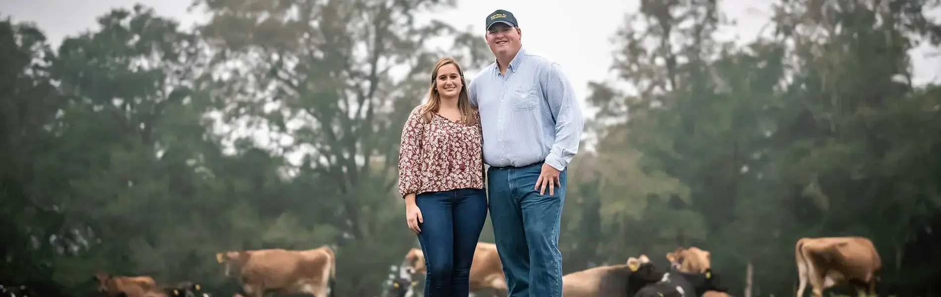 Lussier Family Lussier Family standing in field with milk cows.